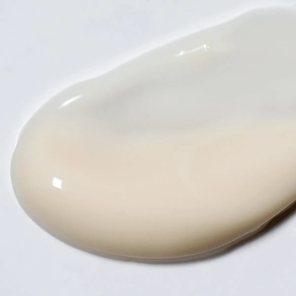 A close-up of LightBoost Eye Cream by Solawave reveals its glossy, creamy texture with off-white and beige tones, enhanced by Vegan Collagen for nourishment.