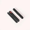 On a light background, three sleek black handheld devices with rounded edges are stacked, each featuring a glowing red strip and the SOLAWAVE text, suggesting their Radiant Renewal Skincare Wand Replacement Carrying Case capabilities. || Black
